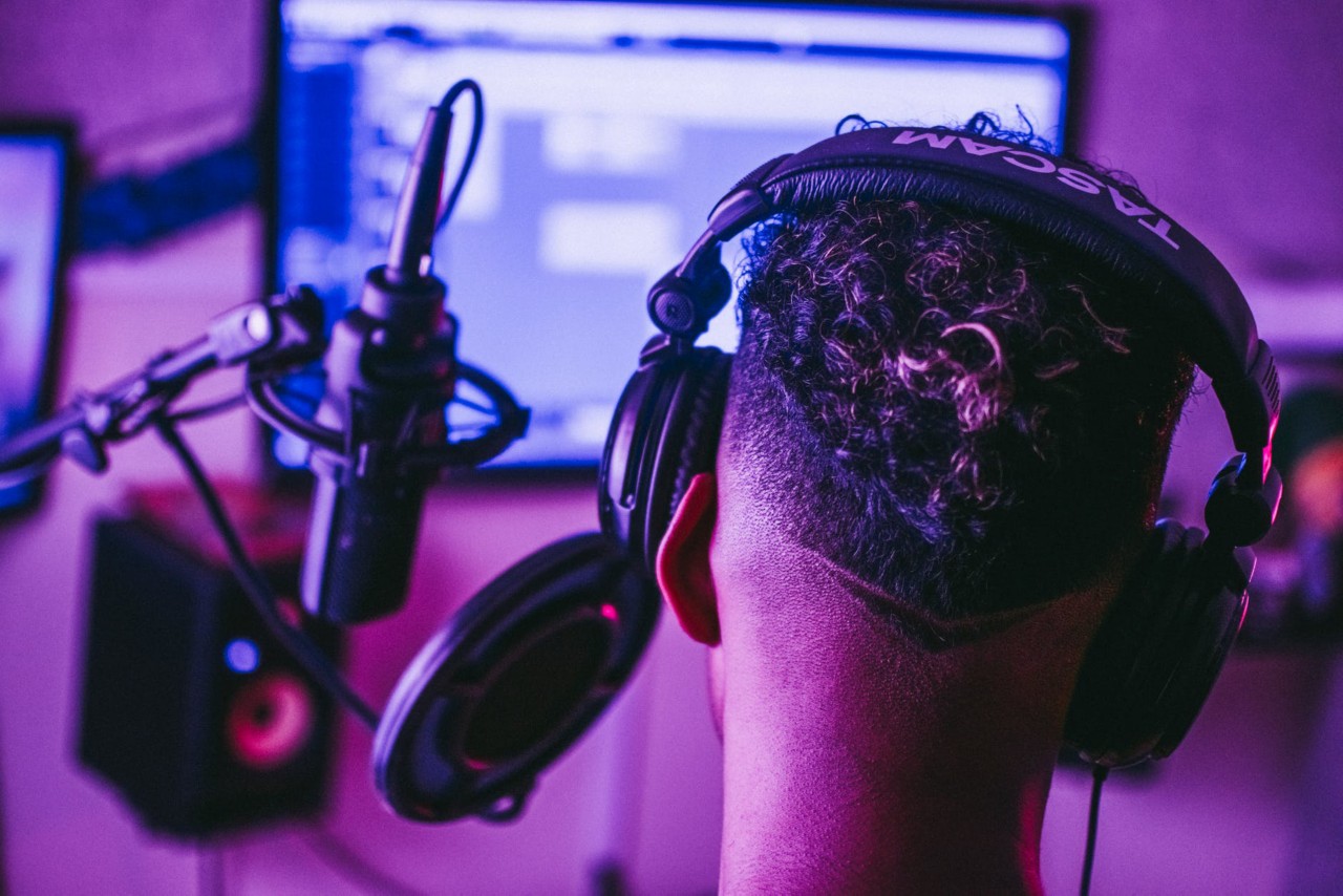 A man with headphones on in front of a computer.